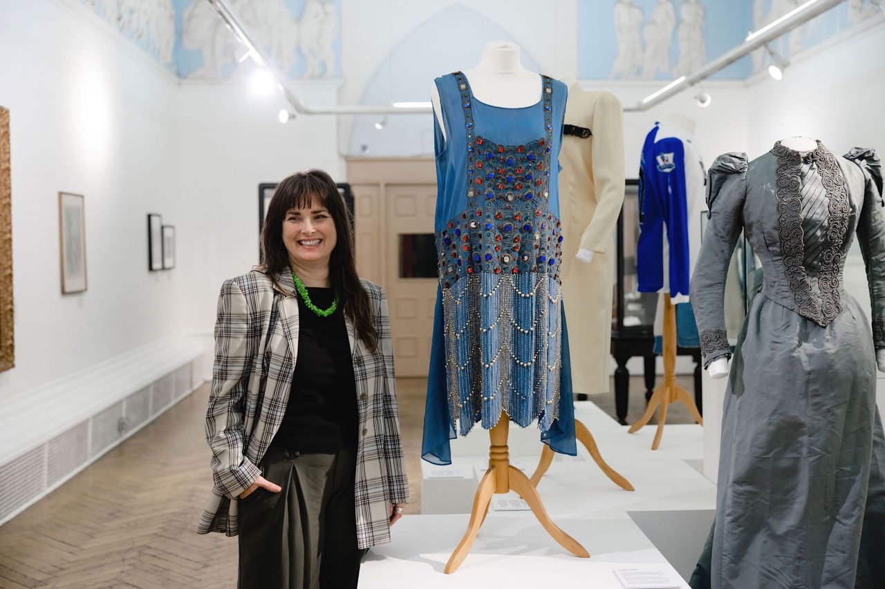 Rebecca Johnson in fron to the Dress for Success Display at Blackburn Museum & Art Gallery. c. Christina Davies, Fish2Photo.