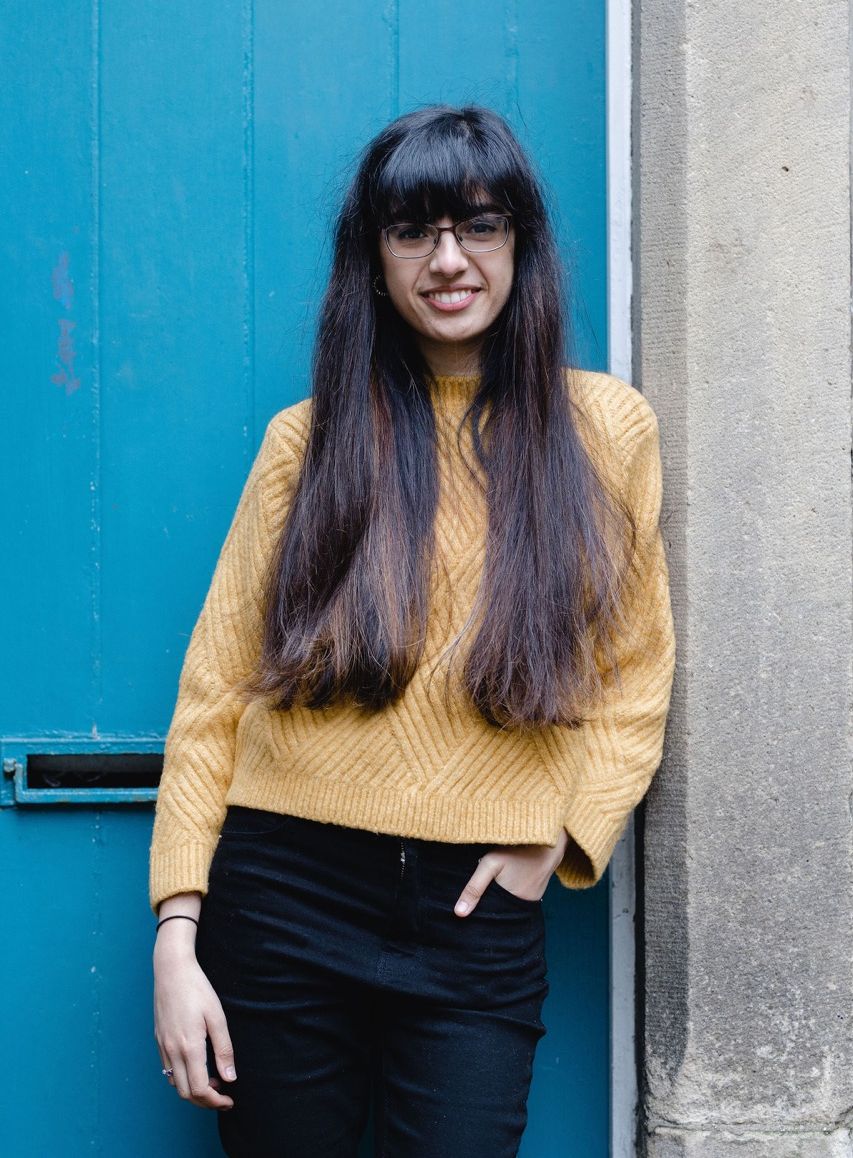 Maariyah Patel standing against a blue door, c. Christina Davies, Fish2Photo