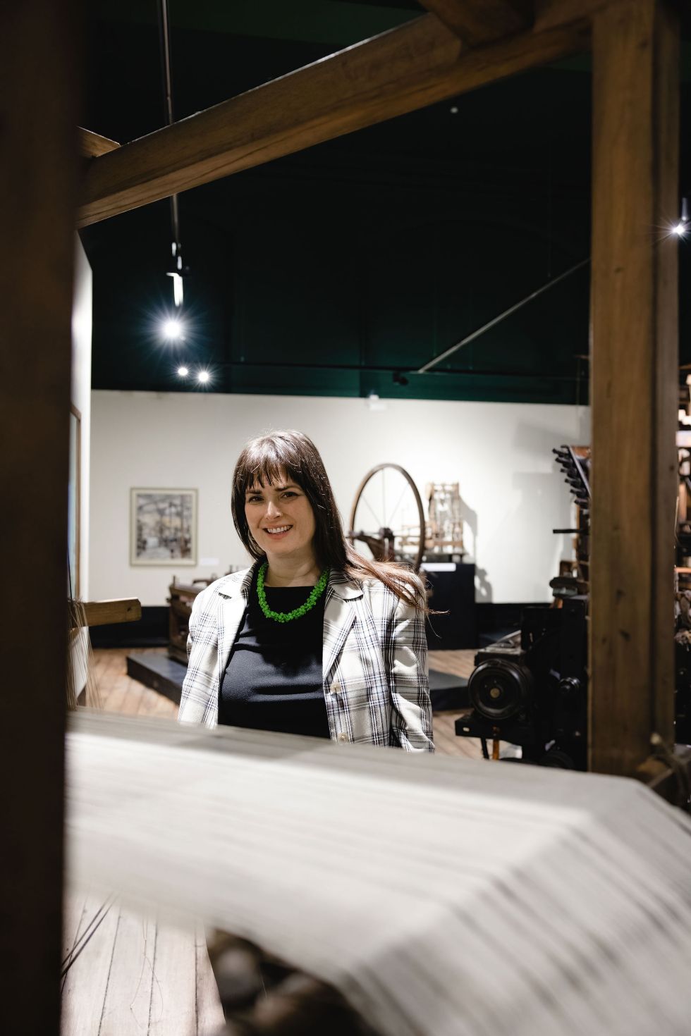 Rebecca Johnson beside a vintage loom at Blackburn Museum & Art Gallery. c. Christina Davies, Fish2Photo.