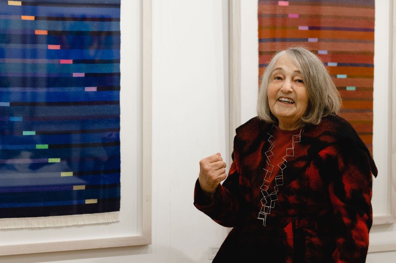 Hannah Smeds-Davies in front of two of her framed textile works at Maiden Bridge Art Gallery. c. Christina Davies, Fish 2 Photo.