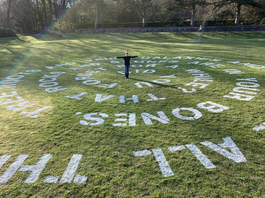 Jackie Jones standing in the middle of a lawn poem for Of Earth and Sky - Corporation Park, Blackburn Festival of Making 2021