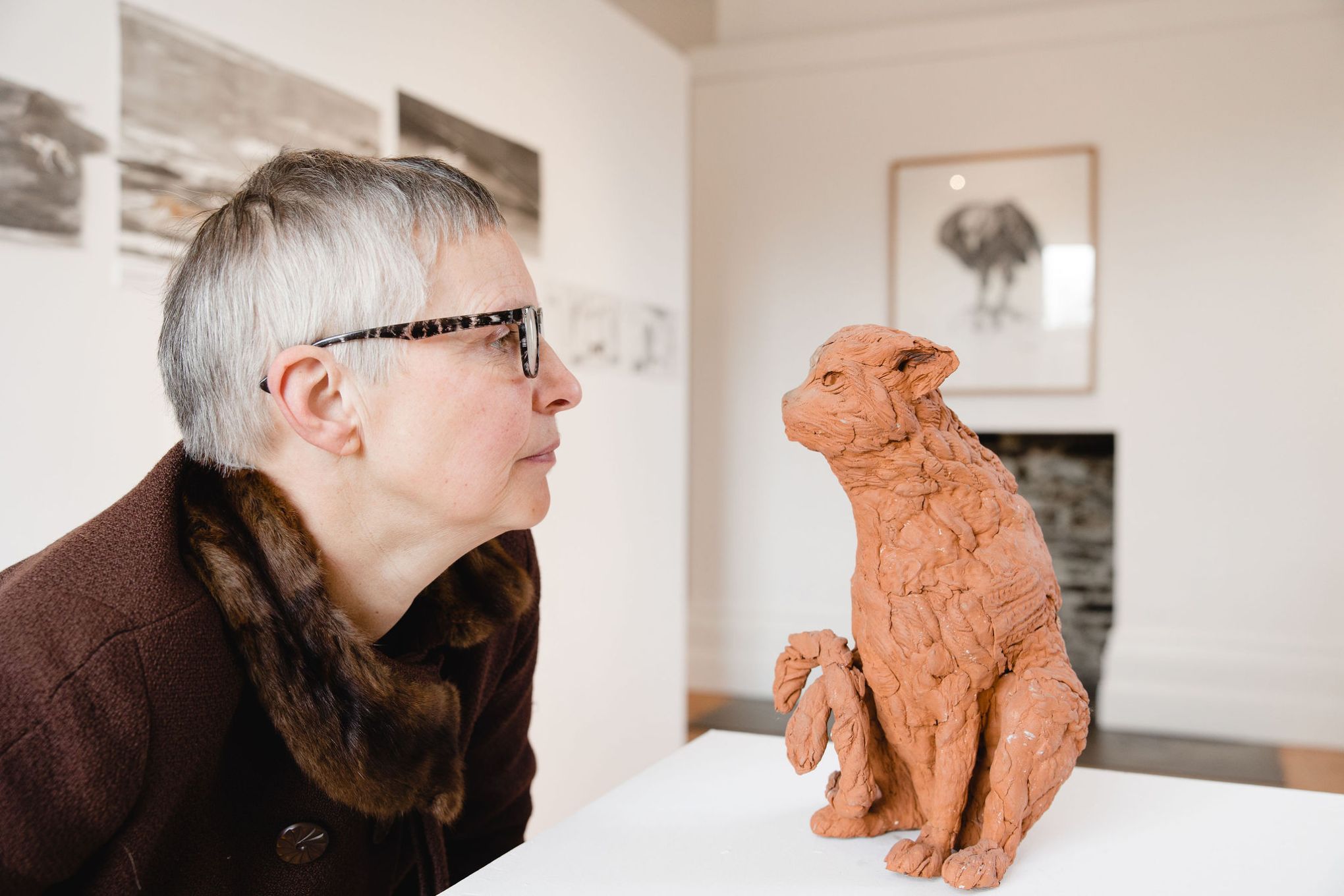 Marjan Wouda with her clay cat sculpture on display at The Whitaker, with her sketches in the background. Image by Christina Davies, Fish2Photo.