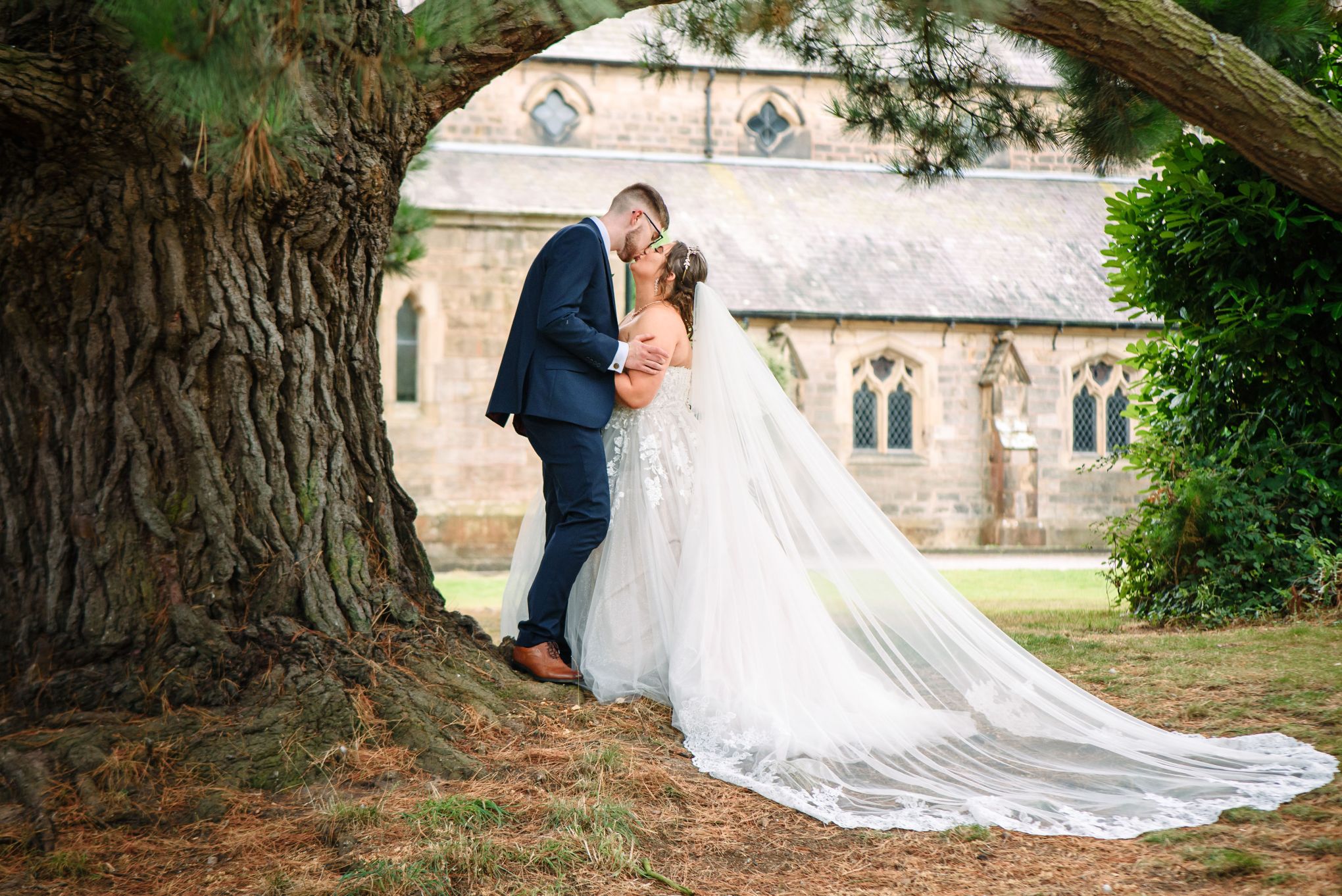 Wedding portrait of couple under a large oak tree. Image by Rachel Ovenden.