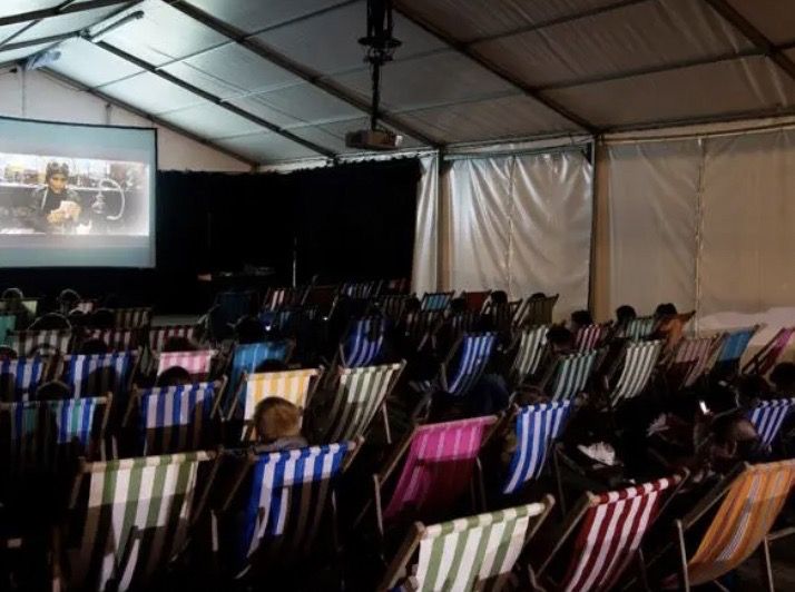 People in deckchairs watching a cinema screen