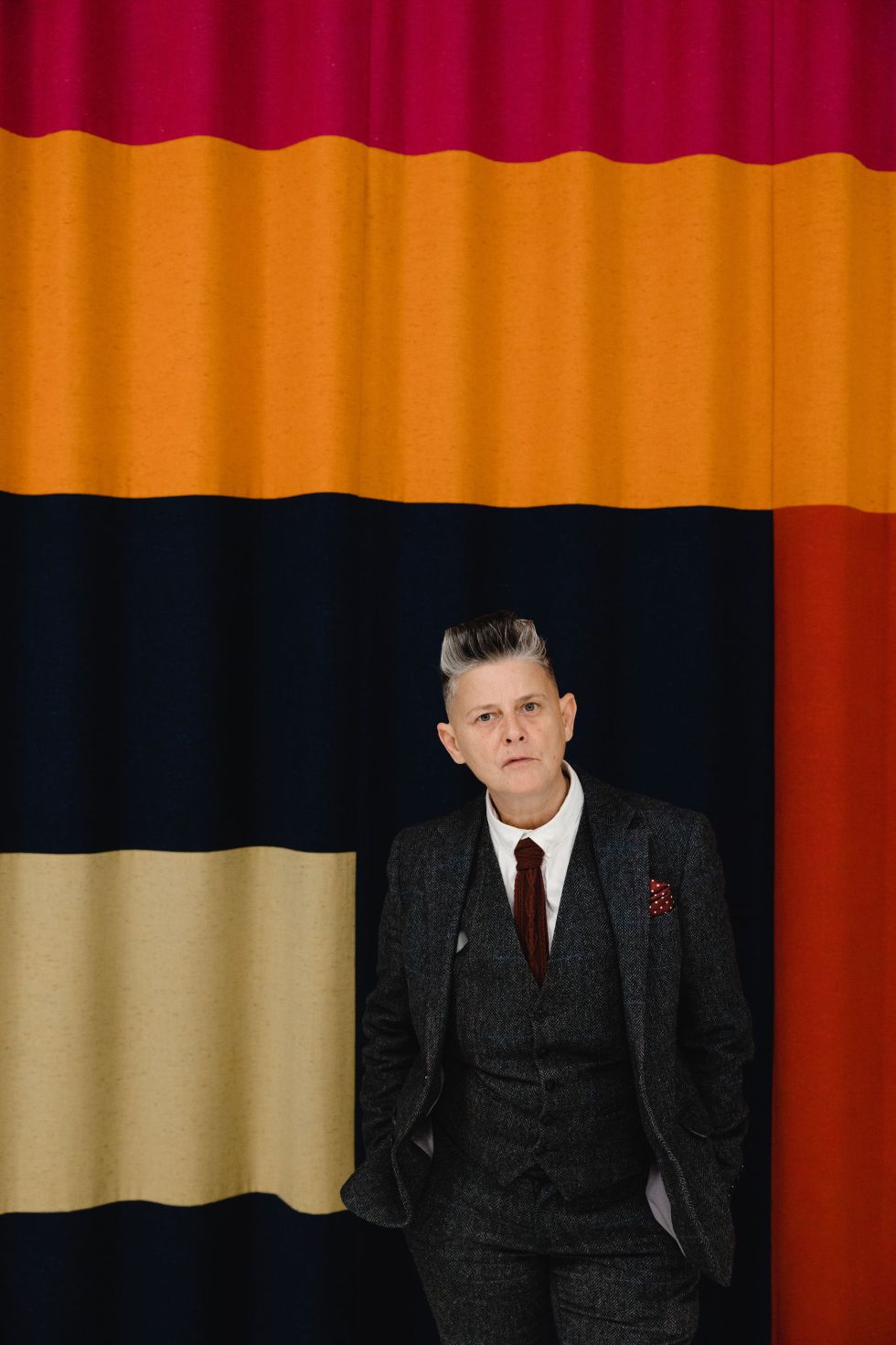 Joelle Taylor standing in front of a curtain with bold design at South Bank Centre. Image by Christina Davies, Fish2Photo