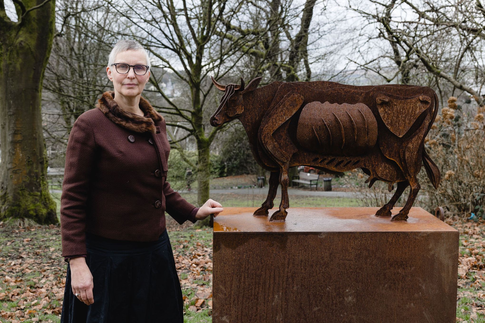 Marjan Wouda with her cow sculpture in the grounds of The Whitaker Museum & Art Gallery. Image by Christina Davies, Fish2Photo.