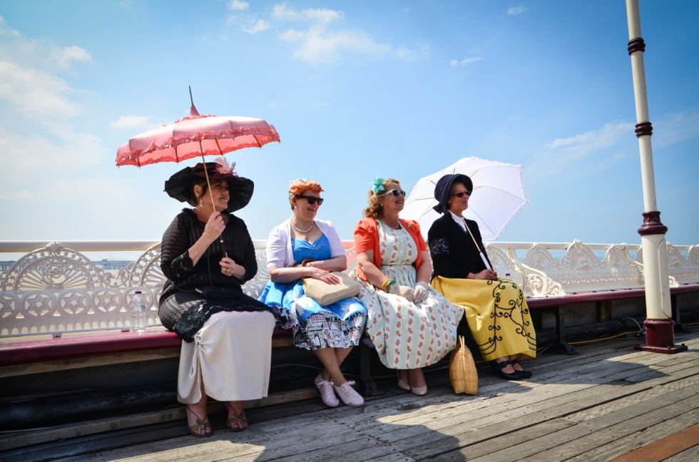 Pier Day image of women sunning themselves dressed in vintage clothing for Aunty Social, Catherine Mugonyi. Image CJ Griffiths.