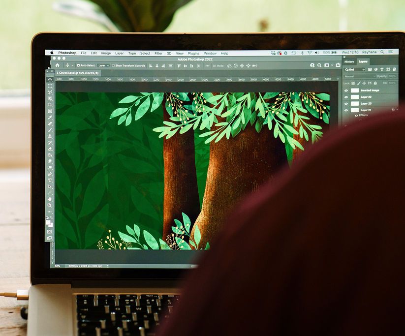 Reyhana Ismail working on a tree illustration on her laptop.